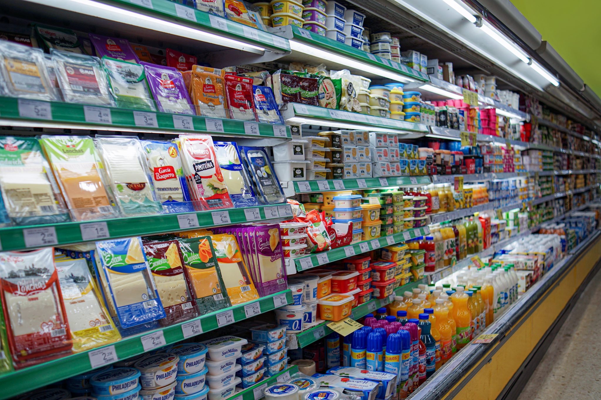 Gôndola de supermercado com prateleiras cheias e grande variedade de produtos embalados