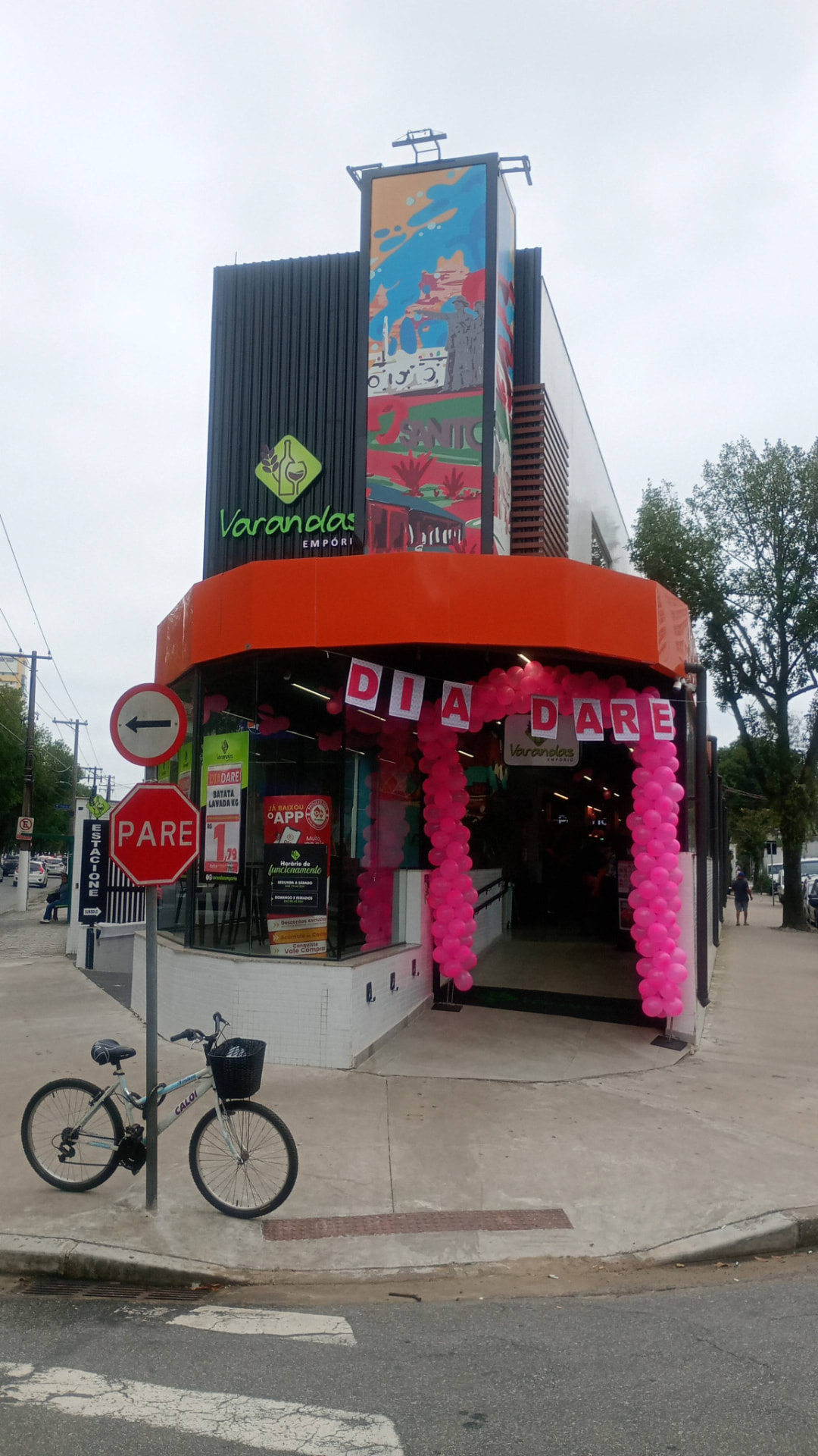Fachada do Varandas Empório com arco de balões rosa e letreiro DIA DARE na entrada.