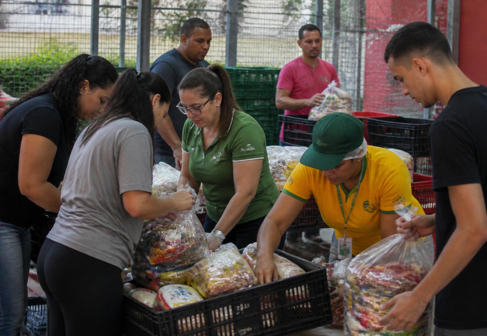 Equipe de supermercado e voluntários organizando doações de alimentos para uma instituição local